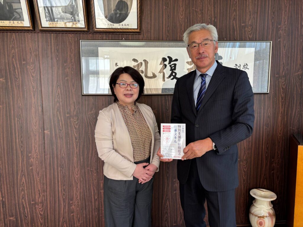 北照高校の校長室で、著書を手にする小路修司先生と安藤あきこ
